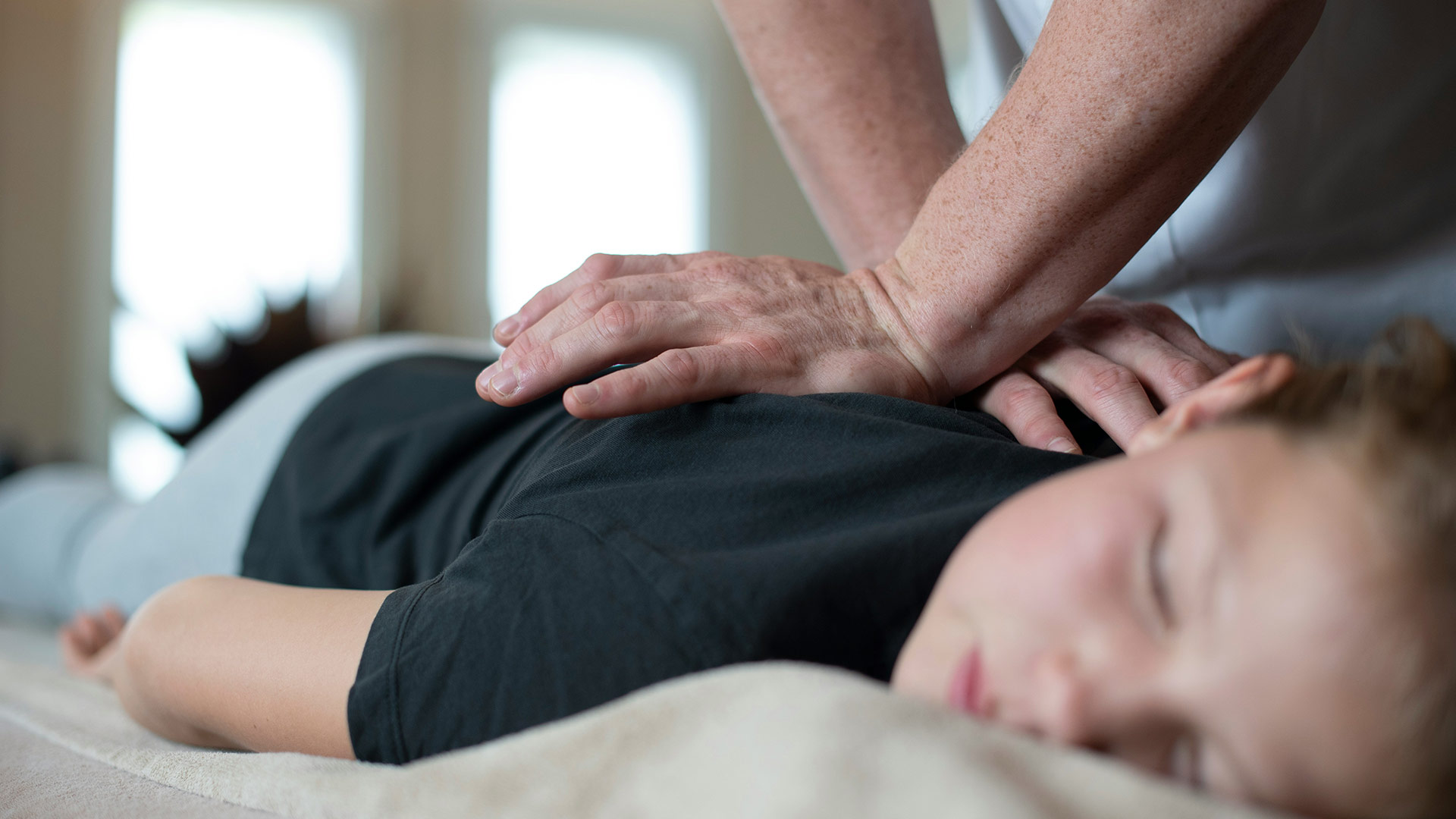 Enfant détendu recevant une séance d’ostéopathie chez Goulmant Ostéo à Toulouse dans une ambiance calme